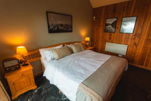 a bedroom with a large bed and two night stands with lamps at Arrayan Lake View Mountain Lodge & Casa De Te Arrayan in San Martín de los Andes