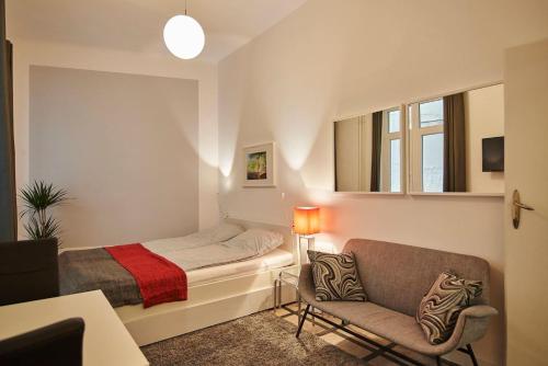 Super Central Studio Apartment - with balcony في بودابست: غرفة نوم صغيرة مع سرير وأريكة