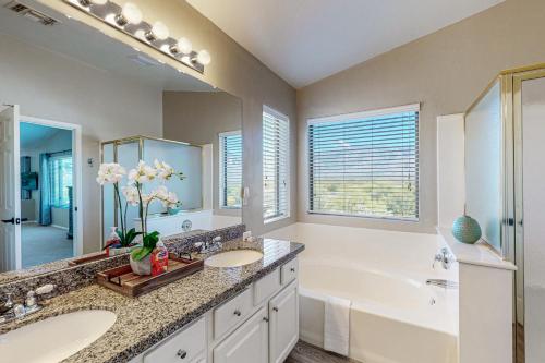 a bathroom with two sinks and a tub and a large mirror at Lemmon Vista in Oro Valley