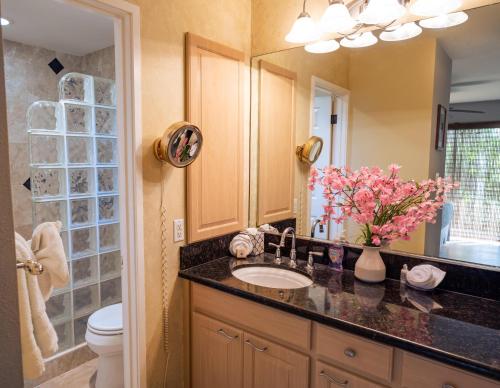a bathroom with a sink and a toilet and a mirror at Ekolu 1403 in Wailea
