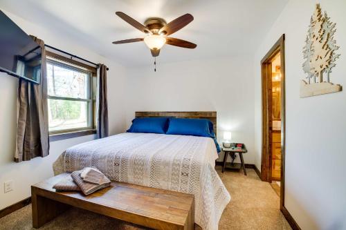a bedroom with a bed and a ceiling fan at Vacation Rental Cabin Near Lake Arbutus! in Hatfield