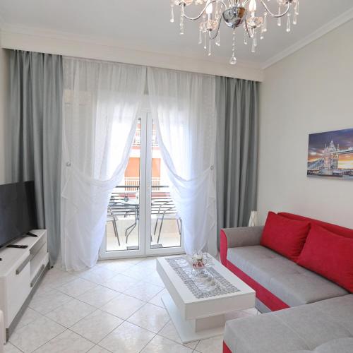 a living room with a couch and a chandelier at Dina's apartment in Iraklitsa in Iraklitsa