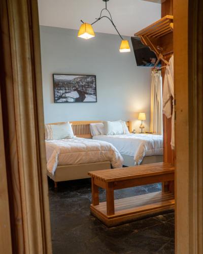a bedroom with two beds and a couch and a table at Arrayan Lake View Mountain Lodge & Casa De Te Arrayan in San Martín de los Andes