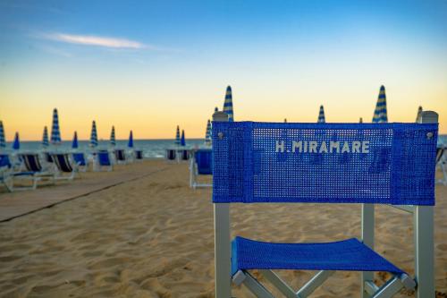 een blauwe mand op een strand met stoelen bij Hotel Miramare - Silvi Marina in Silvi Marina