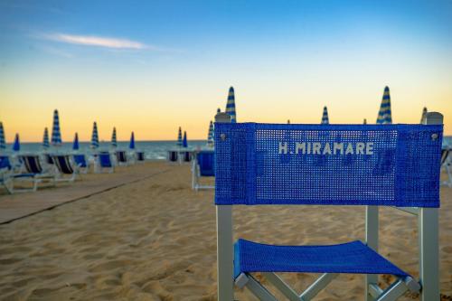 a blue basket sitting on a beach with chairs at Hotel Miramare - Silvi Marina in Silvi Marina
