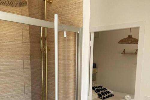 La salle de bains est pourvue d'une douche avec une porte en verre. dans l'établissement L'Or Miroir - Madame Conciergerie, à Bruz