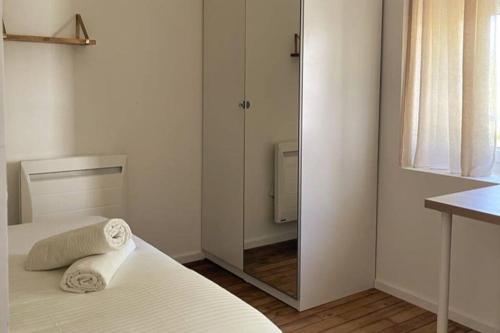 a white bedroom with a mirror and a bed at L'Or Miroir - Madame Conciergerie in Bruz