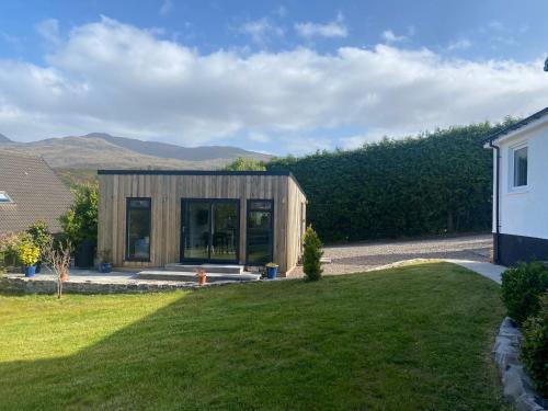 a small wooden house in the middle of a yard at Ardvreck Chalet self-catering in Kyleakin