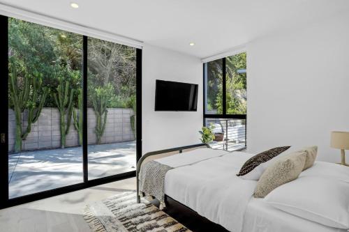 a bedroom with a bed and large windows at Experience Eco-Luxury at its Finest - Centrally Located Clea House in San Diego! in San Diego