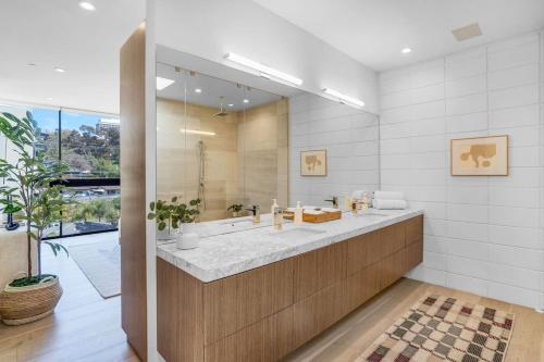 a bathroom with two sinks and a large mirror at Experience Eco-Luxury at its Finest - Centrally Located Clea House in San Diego! in San Diego