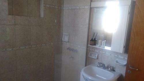 een badkamer met een wastafel, een toilet en een spiegel bij departamento de arriba temporal in Formosa