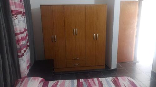 um armário de madeira no canto de um quarto em departamento de arriba temporal em Formosa
