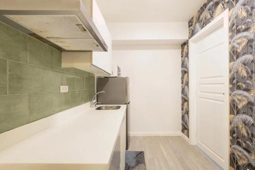 a kitchen with a sink and a refrigerator at Adam's Crib Apartment 2BR by Azure Residences Near Airport in Manila