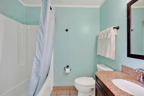 a bathroom with a shower and a toilet and a sink at Admiral's Quarters in Kure Beach