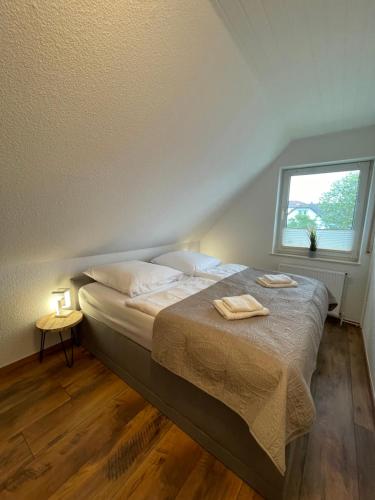 a bedroom with a bed with two towels on it at FeWo-Julius am Weser-Sandstrand in Berne