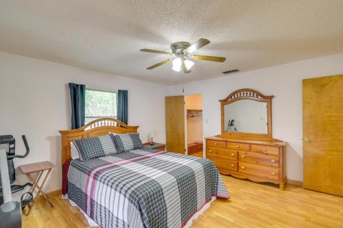 um quarto com uma cama, uma cómoda e uma ventoinha de tecto em East Palatka Vacation Rental, Anglers Paradise em East Palatka