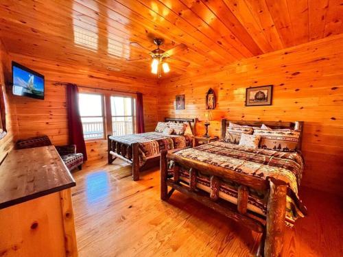 Un dormitorio con dos camas en una cabaña de madera. en * *Luxury 4 Bdrms, Views, Theater, Arcade, Firepit, en Gatlinburg