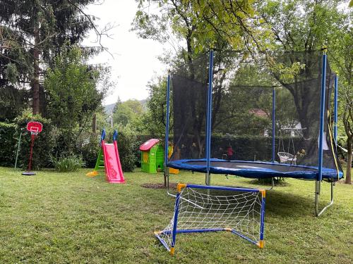 a playground with a trampoline in the grass at Vikendica Fruškogorski kutak - Fruška Gora in Čerević