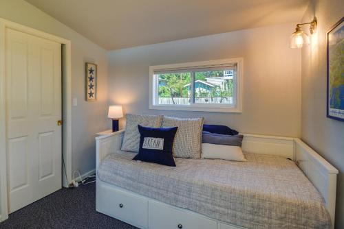 ein Schlafzimmer mit einem Bett mit blauen Kissen und einem Fenster in der Unterkunft Waterfront Hood Canal Cottage Steps to the Beach! in Belfair