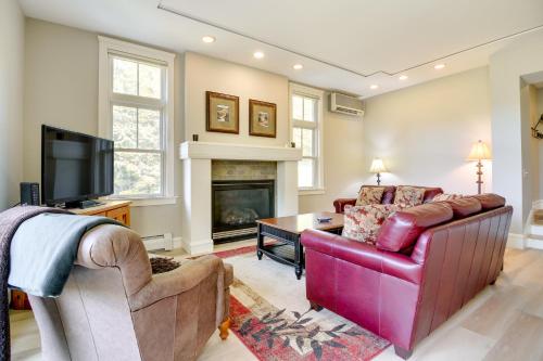 a living room with a red couch and a fireplace at Castle Hill Resort Condo 5 Mi to Slopes at Okemo! in Proctorsville