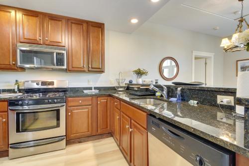 a kitchen with wooden cabinets and stainless steel appliances at Castle Hill Resort Condo 5 Mi to Slopes at Okemo! in Proctorsville