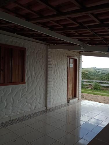 an empty room with a door and a window at Chalés do Apolinário in Tiradentes