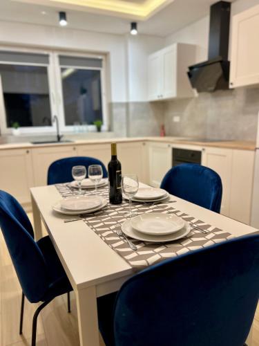 a table with wine glasses and blue chairs in a kitchen at WiLLA APART in Władysławowo