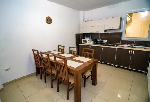 una cucina con tavolo e sedie in legno di Vila Victory a 2 Mai