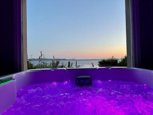 a purple tub with a view of the ocean at Hostal Casa Aurita Adults Only in Sanxenxo
