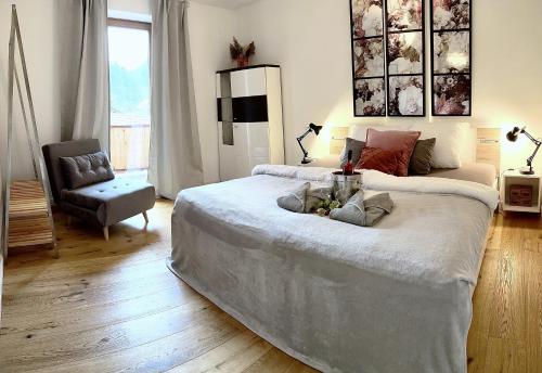 1 dormitorio con 1 cama grande y 1 silla en große Fewo in den Alpen zwischen See, Berg und Bach, en Kiefersfelden