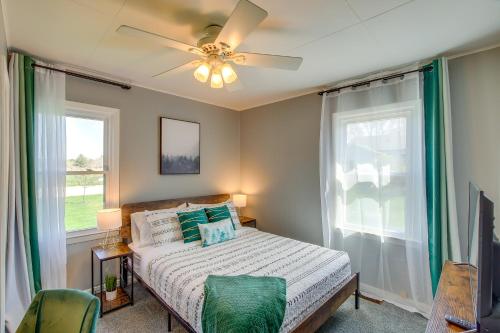 a bedroom with a bed with a ceiling fan and two windows at Sturgeon Bay Home about 6 Mi to Potawatomi State Park in Sturgeon Bay