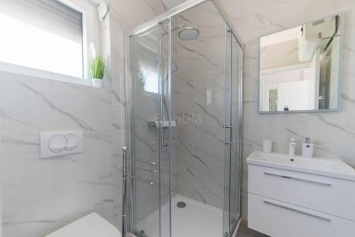 a bathroom with a glass shower and a sink at Villa Adriatic Sunrise in Šibenik