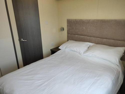 - un grand lit blanc dans une petite chambre dans l'établissement Calm & Cosy (sleeps up to 6) - Oakdene Forest Park, à Ferndown