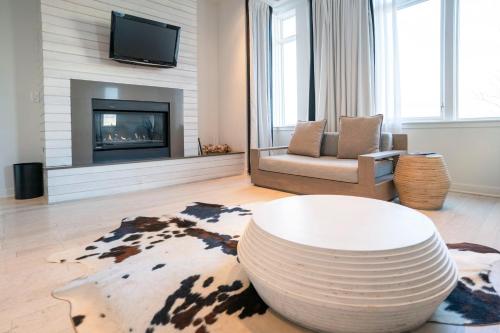 a living room with a table and a fireplace at Bungalow Hotel in Long Branch
