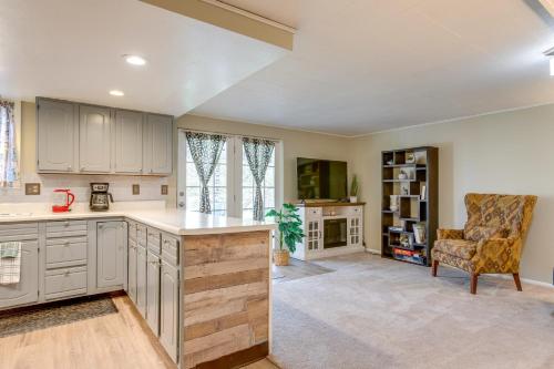 a large kitchen with white cabinets and a chair at 8 Mi to Dtwn Denver Wheat Ridge Gem with Patio in Wheat Ridge