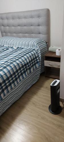 a bedroom with a bed and a wooden floor at habitacion Depto Business in Santiago