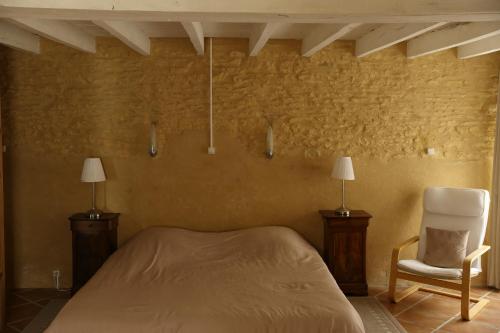 - une chambre avec un lit et une chaise dans l'établissement les Tours de Bombel, à Saint-Amand-de-Coly