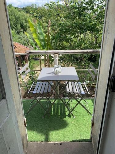 an open door with a table and chairs on a balcony at Le Périgourdin in Saint-Cyprien