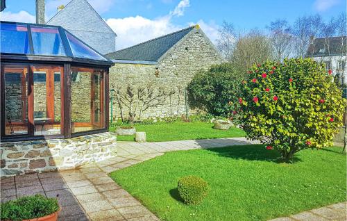 une maison avec un jardin agrémenté d'un arbre et d'une fenêtre dans l'établissement Holiday Home Rue Du Calvaire, à Le Cloître-Saint-Thégonnec