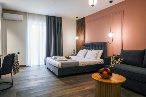 um quarto de hotel com uma cama e um sofá em CASA DIVINUS SUITES em Atenas