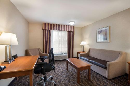 a hotel room with a couch and a desk at Best Western Norwalk Inn in Norwalk