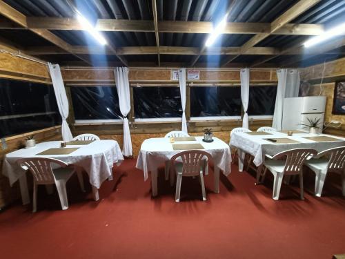 a group of tables in a room with windows at Alojamento Local Largo da Igreja in Santiago do Cacém