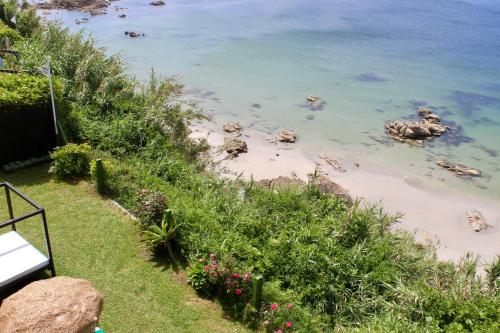 a view of a beach with rocks in the water at Hostal Casa Aurita Adults Only in Sanxenxo