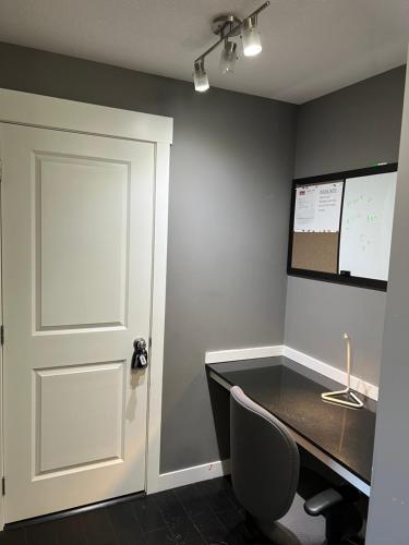 una oficina con puerta, escritorio y pantalla en Lovely 2 bedroom 2 bathroom plus den, en Calgary