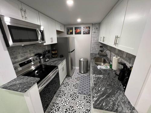 a kitchen with white cabinets and a black and white tile floor at Tranquility in paradise- 2 bedroom villa w/parking in Hilton Head Island
