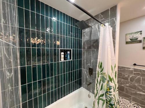 a bathroom with a green tiled wall and a bath tub at Tranquility in paradise- 2 bedroom villa w/parking in Hilton Head Island