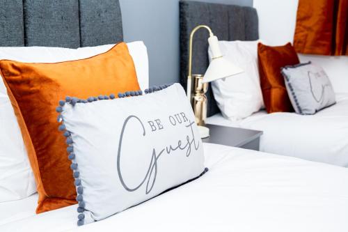 a bed with a pillow that says be our guest at DUDLEY 3 Bedroom House-PERFECT FOR CONTRACTORS-FAMILIES-LEISURES-LONG STAY in Woodside