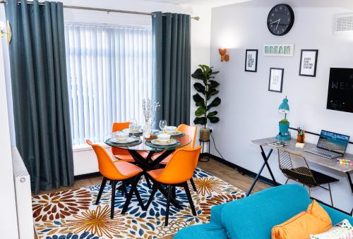 a living room with a table and orange chairs at DUDLEY 3 Bedroom House-PERFECT FOR CONTRACTORS-FAMILIES-LEISURES-LONG STAY in Woodside