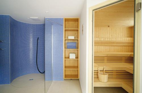 a bathroom with a shower with blue tiles at Ferienappartements Annemarie in Oberstdorf