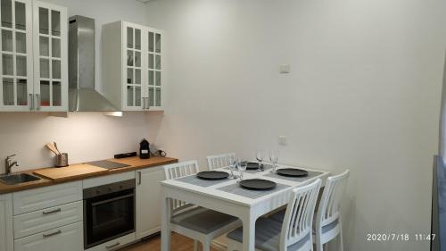 une cuisine avec une table blanche et des armoires blanches dans l'établissement T1 Bis neuf climatisé tout équipé #1, à Toulon